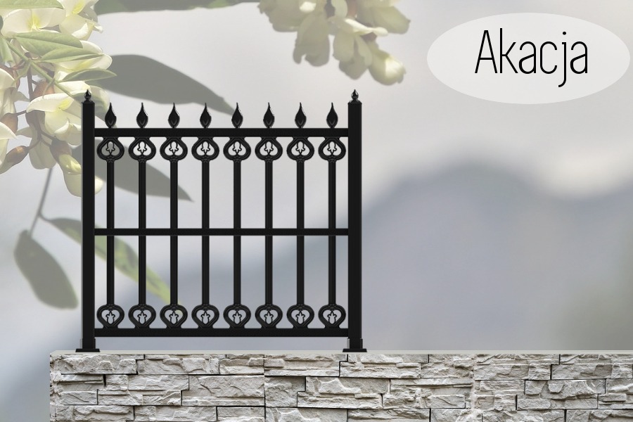 Fragment czarnego ogrodzenia z metalowymi prętami zakończonymi motywem serca, zamontowany na murku z jasnego kamienia, w tle kwiaty akacji i napis 'Akacja'.