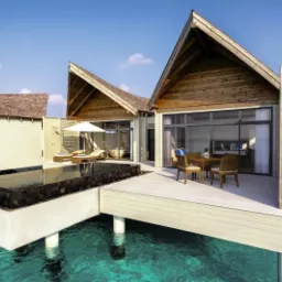 Luksusowy bungalow na wodzie z klimatyzacją, widok na ocean, drewniana konstrukcja, basen i taras z meblami.