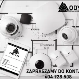Kamera kopułkowa, czujnik ruchu i tablet z logo firmy na planie architektonicznym domu. Całość w stonowanej kolorystyce.