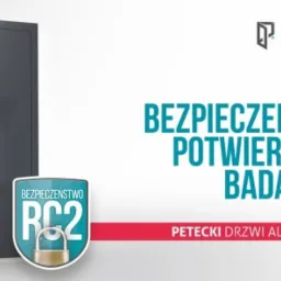 Nowoczesne, grafitowe drzwi zewnętrzne z długim, srebrnym uchwytem i pionowym akcentem, prezentowane na białym tle z informacją o certyfikacie bezpieczeństwa RC2 i logo producenta.