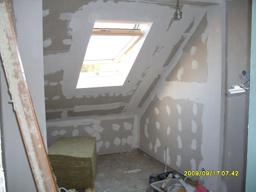 Poddasze w trakcie remontu: widoczne płyty karton gips na skosach, okno dachowe, ocieplenie w kostce, ślady szpachlowania i data wykonania zdjęcia w prawym dolnym rogu.