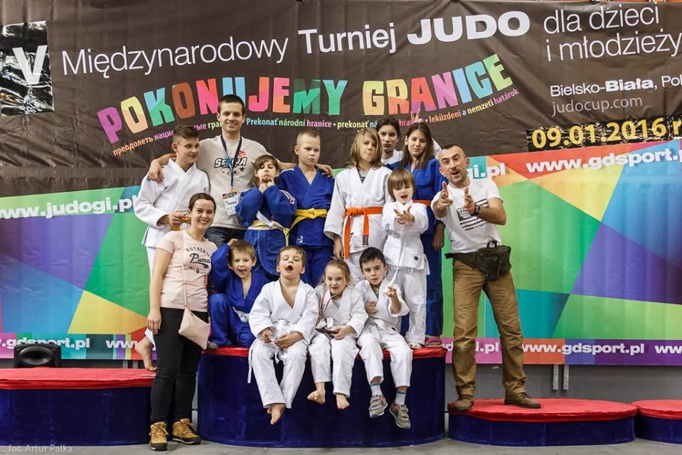 Grupa dzieci w kimonach judo i dorośli na podium podczas Międzynarodowego Turnieju Judo Pokonujemy Granice w Bielsku-Białej, 09.01.2016.
