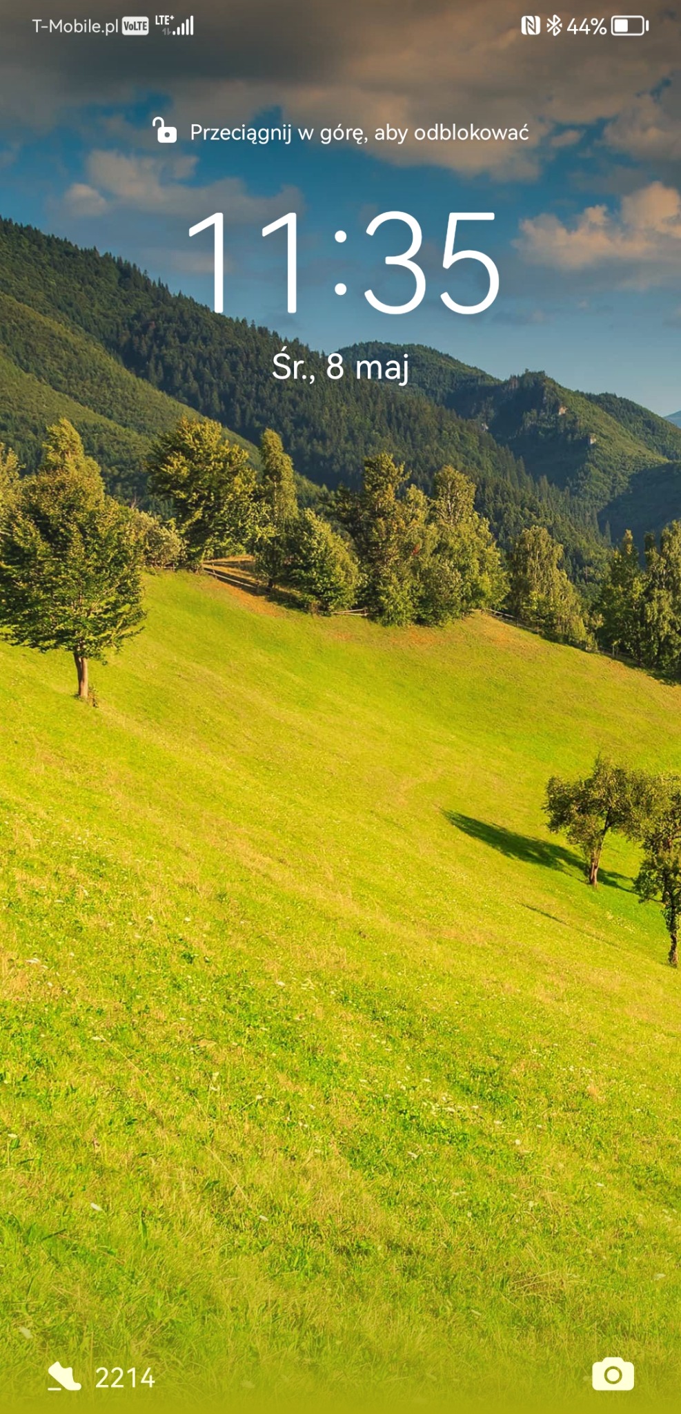 Zrzut ekranu telefonu komórkowego z widokiem na zielone wzgórza i góry w tle, godzina 11:35, środa, 8 maja.