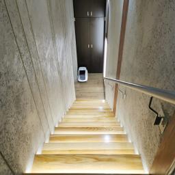Położenie nowych drewnianych schodów z oświetleniem Led oraz tynk betonowy z dodatkiem struktury  drewna na ścianie, wykończenie podłogo gresem z ogrzewaniem podłogowym na wejściu. 