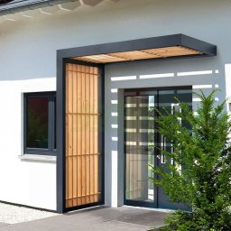 Elkano - Nowoczesne zadaszenie nad wejściem do domu z elementami drewnianymi i metalową konstrukcją, widok z zewnątrz.