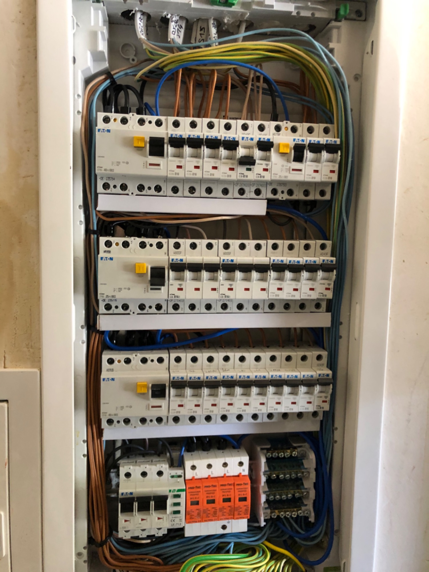 Otwarta skrzynka bezpiecznikowa z zainstalowanymi wyłącznikami i okablowaniem w Wejherowie, widoczne bezpieczniki Eaton i różnokolorowe przewody.