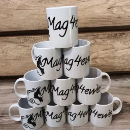 Piramida z białych kubków z czarnym napisem 'Mag4ewel', część kubków ma dodatkowo czarny rysunek profilu kobiety, tło z drewnianych desek.