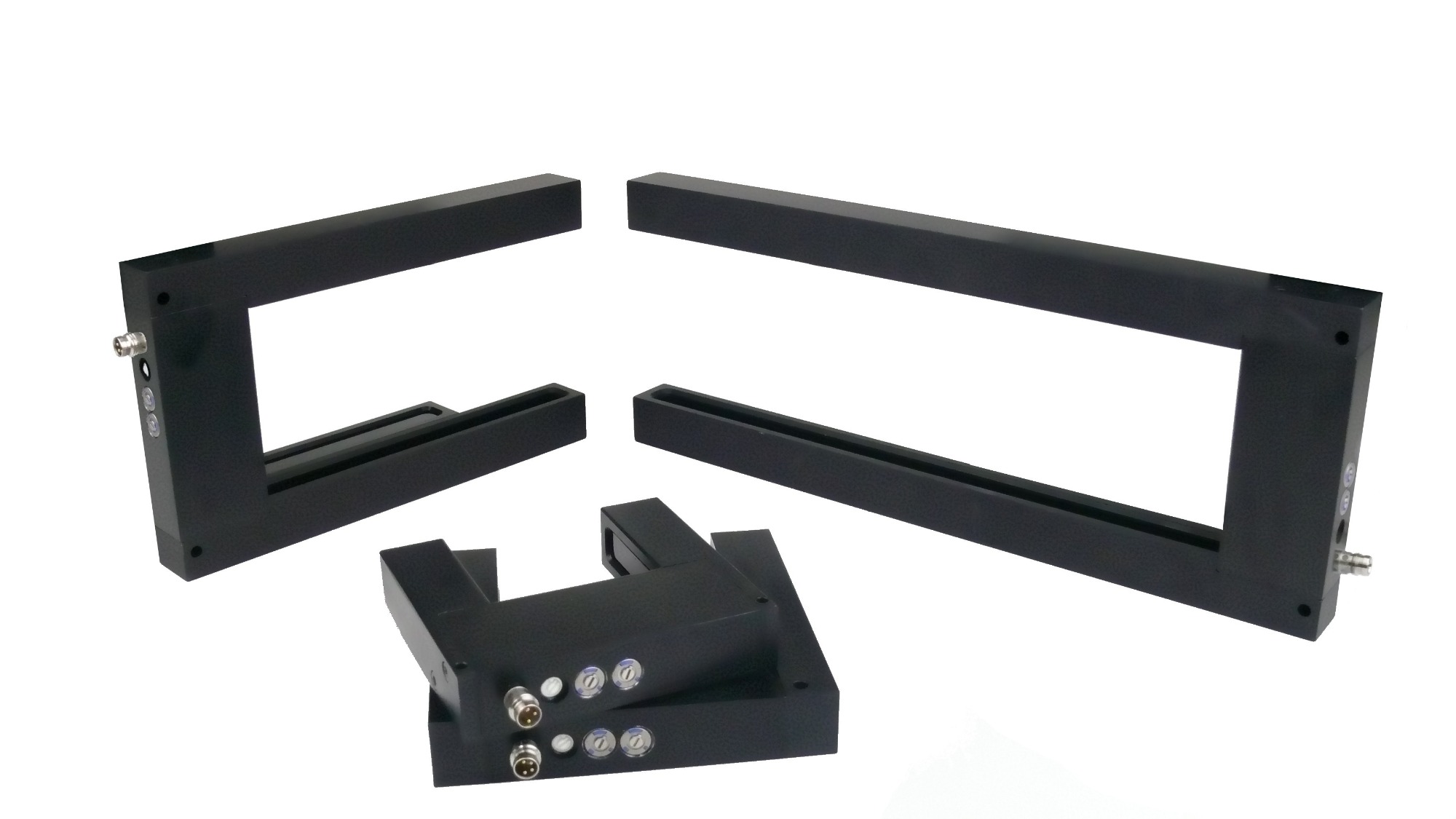 Zestaw czarnych, metalowych czujników krawędziowych z widocznymi złączami i śrubami, ułożonych na białym tle.