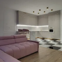 Nowoczesne wnętrze: szara kuchnia z marmurowym blatem i złotymi akcentami, fioletowa sofa w salonie, czarno-biała podłoga w szachownicę, drewniana podłoga w salonie.