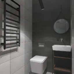 Nowoczesna łazienka w szarościach z podwieszaną toaletą, grzejnikiem drabinkowym i okrągłym lustrem zawieszonym na pasku.