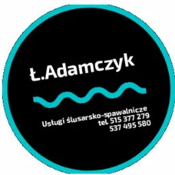 Okrągłe logo firmy z czarnym tłem i turkusową obwódką, zawierające napis 'Ł.Adamczyk' nad symbolem przypominającym falę, a pod spodem tekst 'Usługi ślusarsko-spawalnicze' i numery telefonów.