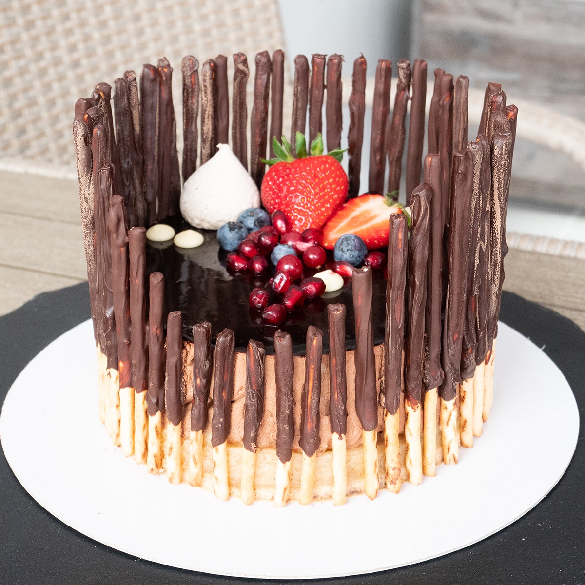 Oryginalny tort biszkoptowy z musem jabłkowym, masą śmietankową, prawdziwą czekoladą oraz świeżymi owocami.