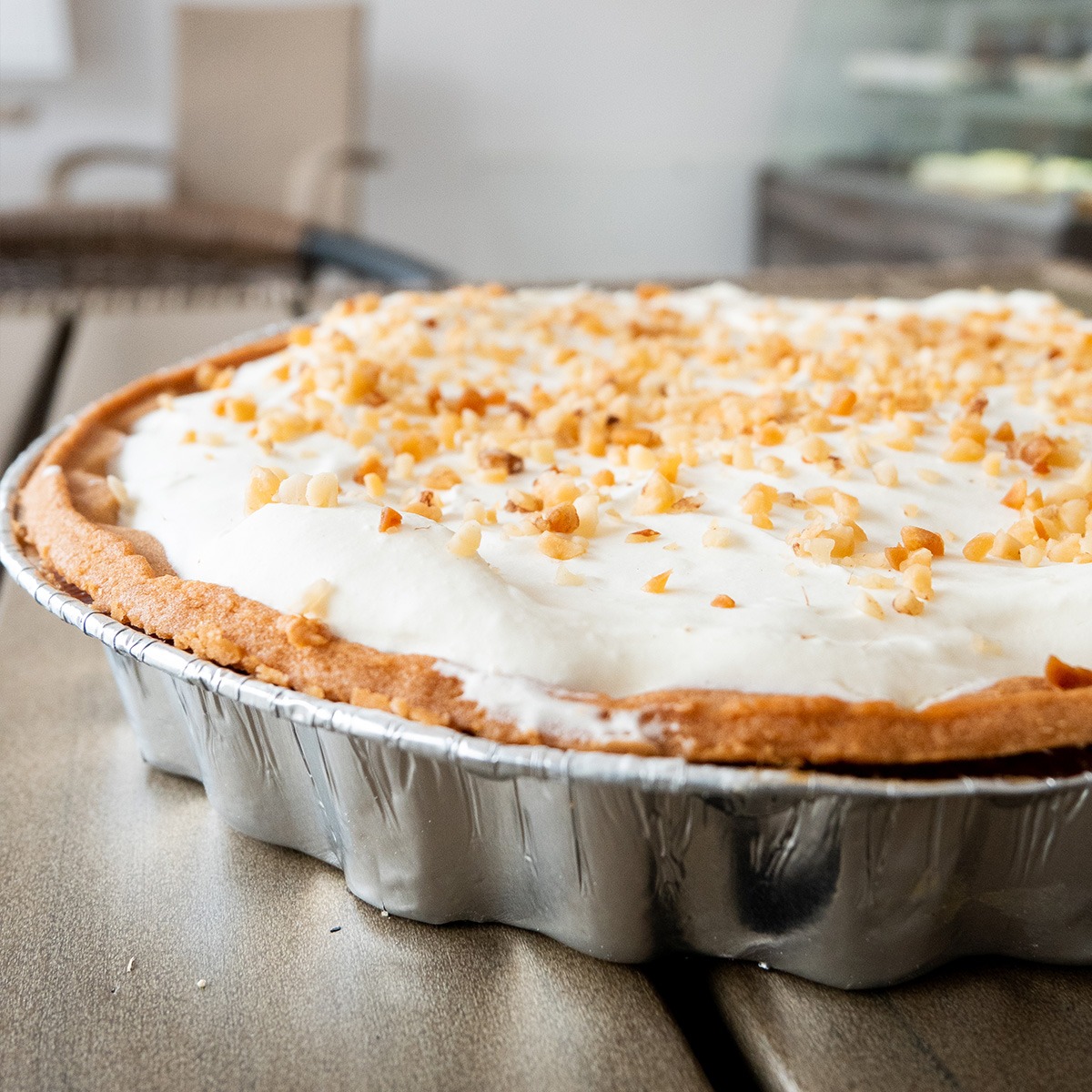 Tarta bananowo-krówkowa z bitą śmietaną i orzechami.