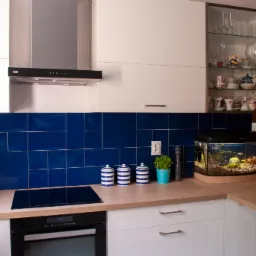 Nowoczesna kuchnia z białymi szafkami, drewnianym blatem, niebieskimi kafelkami, akwarium i szklaną witryną z porcelaną.