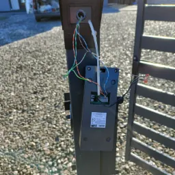 Montaż panelu sterowania przy bramie w Kąclowej, widoczne kable i złącza, instalacja w trakcie realizacji.