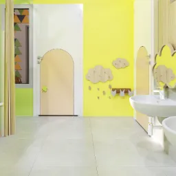 Jasne, przestronne wnętrze łazienki dla dzieci z żółtymi ścianami i kabinami, umywalkami w kształcie chmur, drewnianymi wieszakami i ozdobnymi detalami, utrzymane w minimalistycznym stylu.