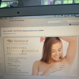 Zdjęcie ekranu laptopa z otwartą wiadomością e-mail zawierającą reklamę depilacji laserowej z uśmiechniętą kobietą prezentującą gładką skórę pod pachami.