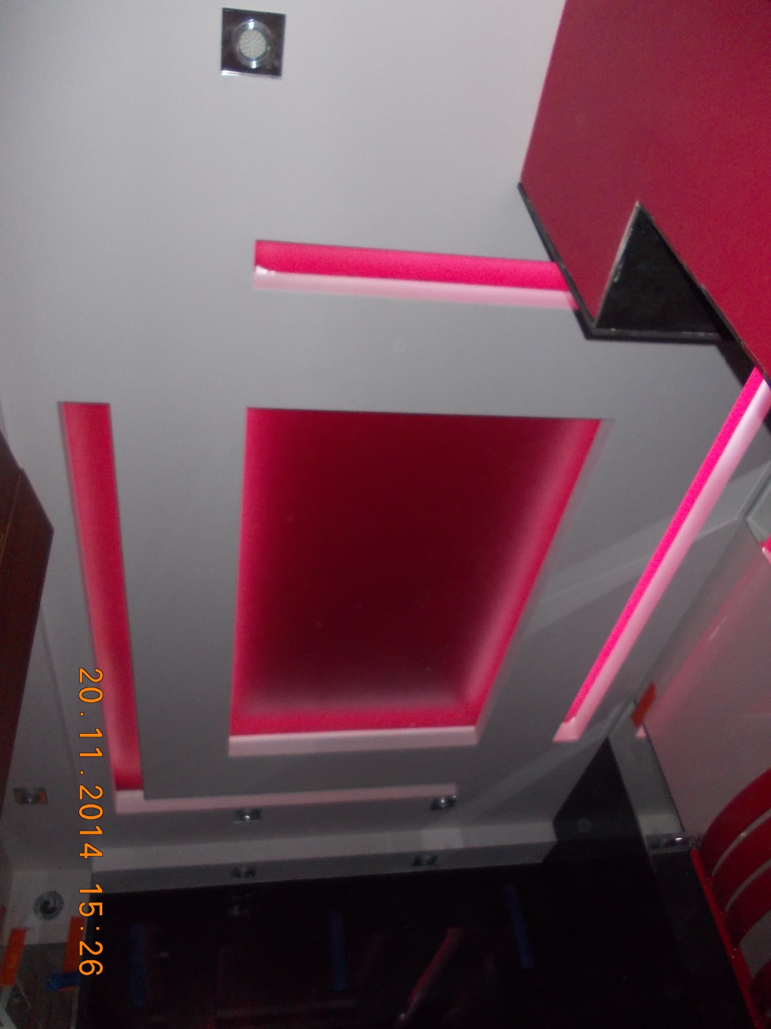 Sufit podwieszany z oświetleniem LED w kolorze różowym, widoczne elementy konstrukcyjne i punktowe oświetlenie.