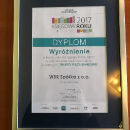 Oprawiony w srebrną ramkę dyplom 'Księgowy Roku 2017' dla WBR Spółka z o.o., przyznany przez Dziennik Gazeta Prawna, z widocznym podpisem redaktora naczelnego i logotypami partnerów.