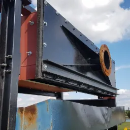 Konstrukcja stalowa z elementami pomalowanymi na czarno i czerwono, skręcana śrubami, widoczna na tle błękitnego nieba z obłokami, wykonana w Łukowie.