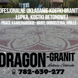 Wykończona nawierzchnia z kostki brukowej ułożonej w dekoracyjny wzór kwiatowy, z widocznym logo firmy Dragon-Granit i numerem telefonu, tło z zielenią ogrodową.