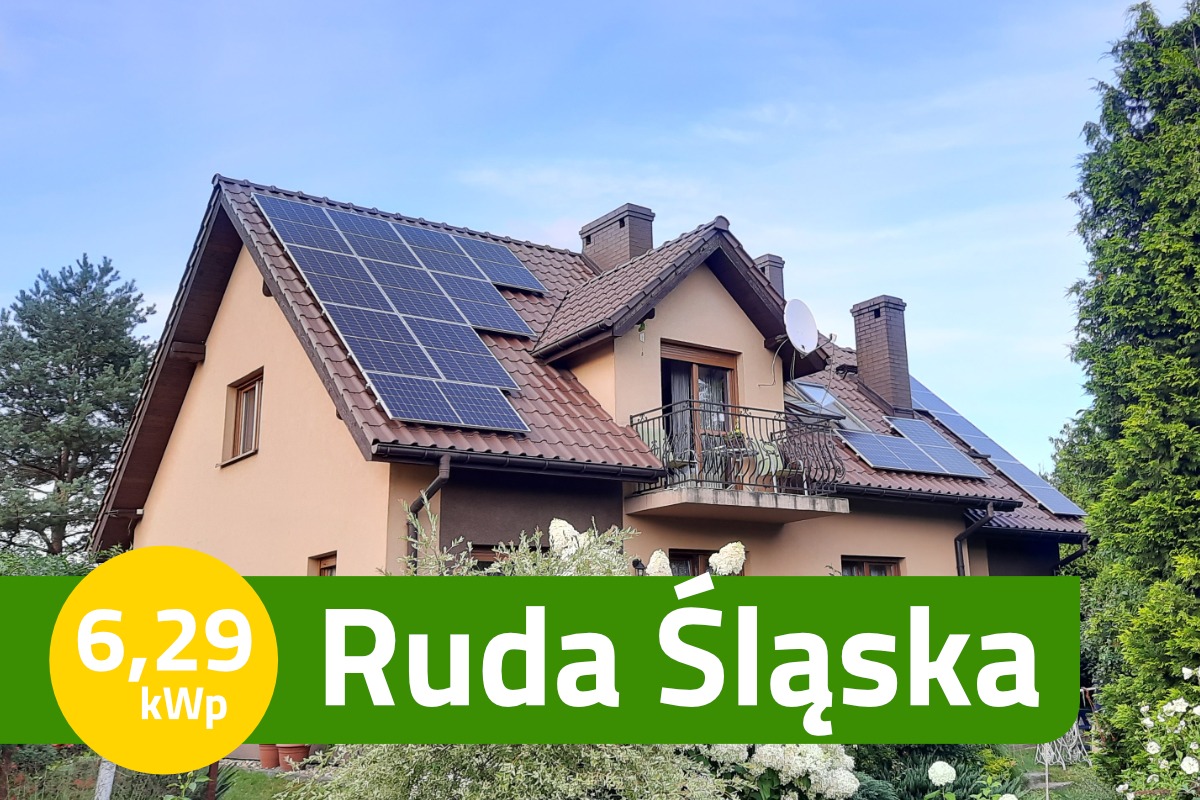 Dom jednorodzinny z brązowym dachem, na którym zamontowano panele słoneczne; widoczna antena satelitarna na kominie.