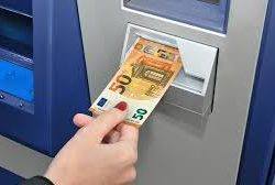 Wkładanie banknotu 50 euro do bankomatu; widoczne dłonie z czerwonym manicure.