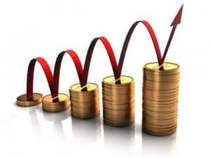 Graficzne przedstawienie wzrostu finansowego: stosy złotych monet z czerwoną strzałką wskazującą trend wzrostowy.