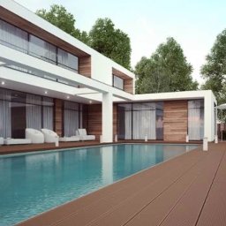 FHU Heda Adam Heda - Nowoczesny dom z basenem i drewnianym tarasem, białe meble ogrodowe i parasol, duże okna z zasłonami, otoczony zielenią.