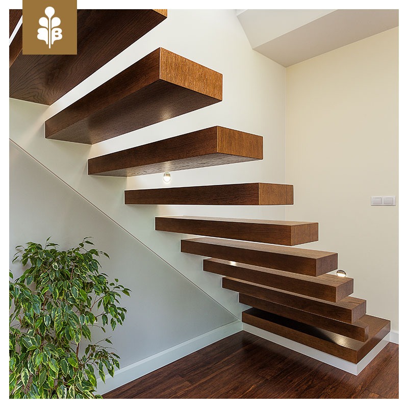 Nowoczesne, wiszące schody z ciemnego drewna z wbudowanym oświetleniem punktowym, widok z dołu z rośliną doniczkową w lewym dolnym rogu.