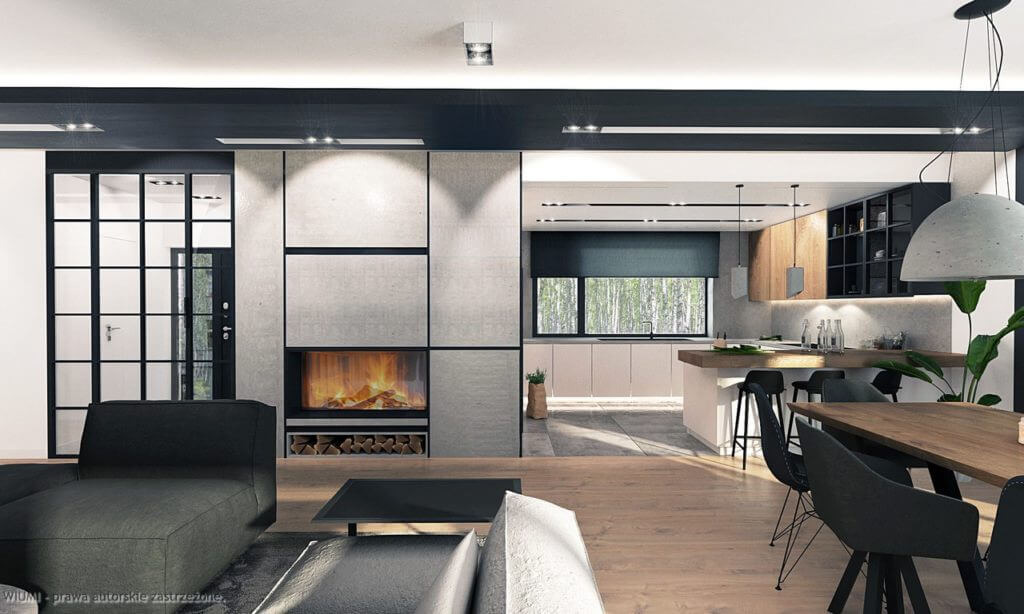 Nowoczesne wnętrze domu z otwartą przestrzenią: salon z kominkiem i kuchnia z wyspą, drewniana podłoga, czarne detale, duże okno z widokiem na zieleń.