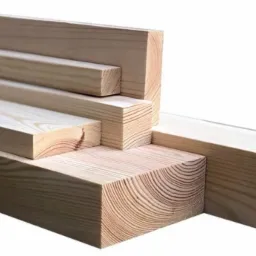 Stos jasnych, oheblowanych belek z widocznymi słojami drewna, ułożonych warstwowo na białym tle.