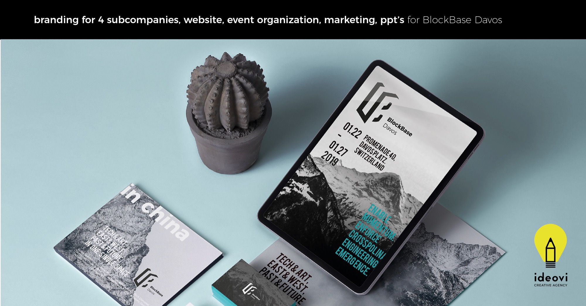 Prezentacja identyfikacji wizualnej BlockBase Davos, obejmująca tablet z wyświetlonym projektem, wizytówki, broszurę 'in china' i dekoracyjny kaktus w doniczce, wszystko na jasnoniebieskim tle.