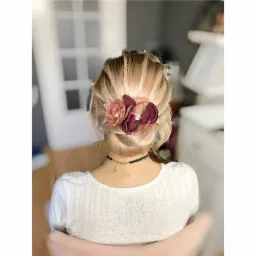 Upięcie blond włosów z ozdobnymi, bordowo-różowymi kwiatami z tkaniny i siateczki, widok z tyłu, delikatny choker na szyi.