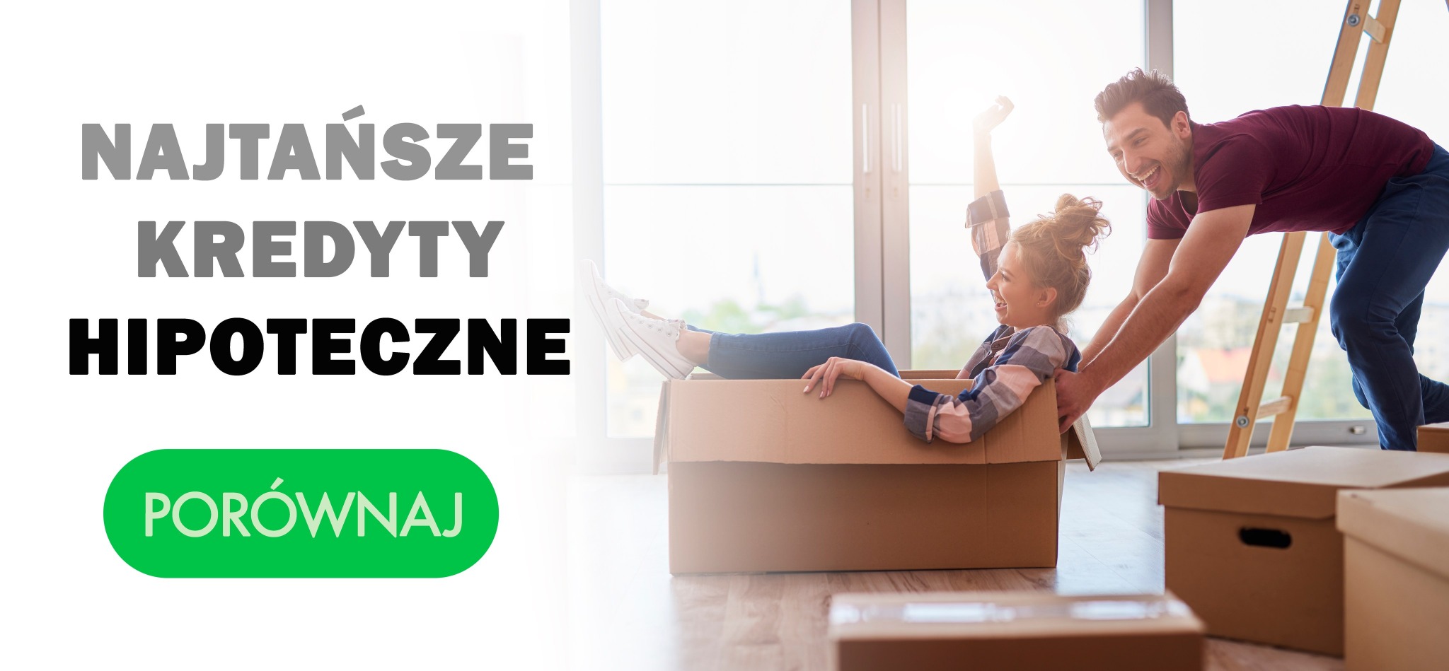 Radosna para podczas przeprowadzki: kobieta siedzi w kartonie, mężczyzna ją pcha, w tle okno i drabina.