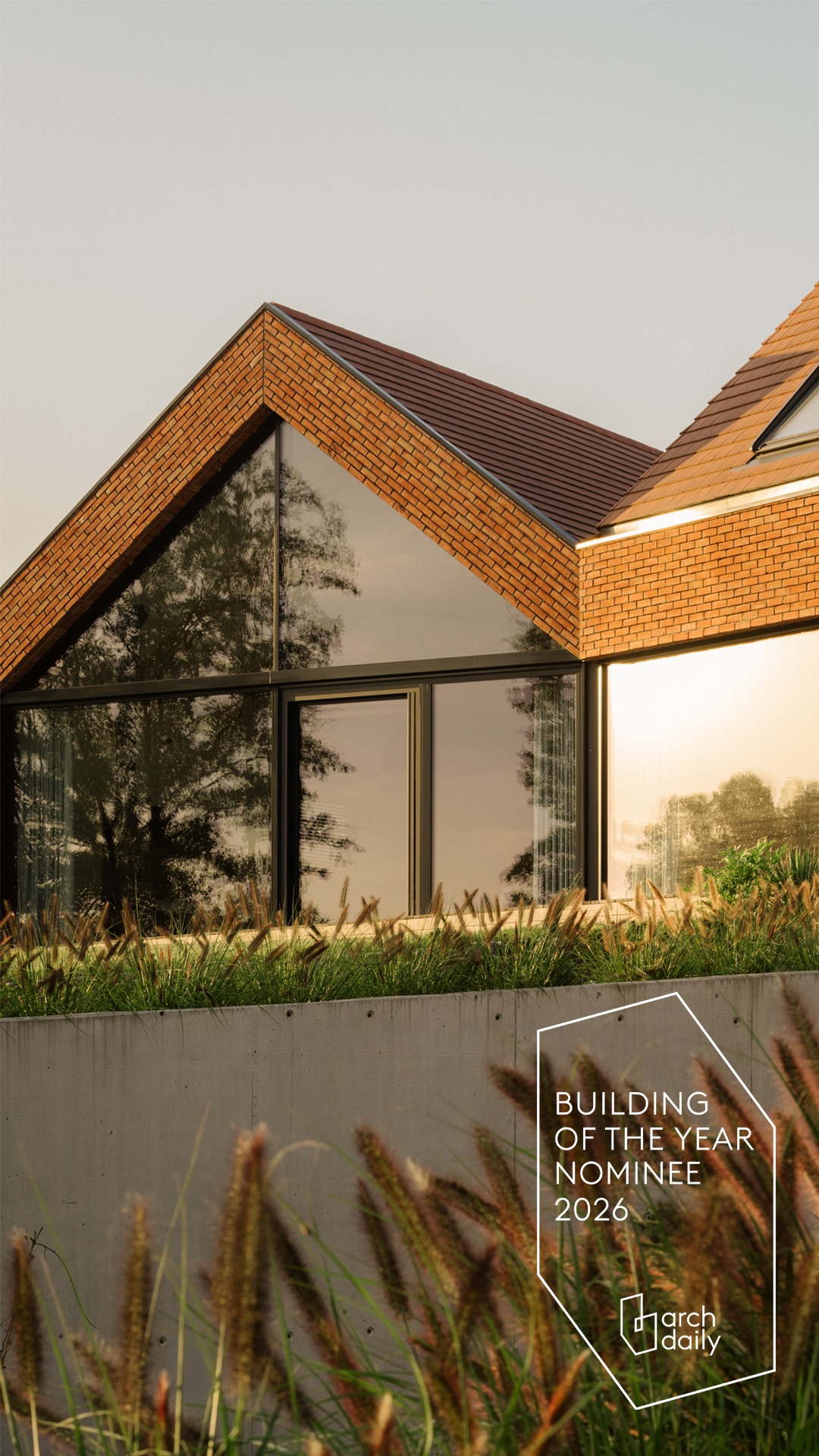 Nowoczesny dom z ceglaną elewacją i dużymi oknami, nominowany do nagrody 'Building of the Year 2026' przez ArchDaily. Minimalistyczny design, naturalne światło.