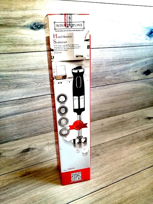 Pudełko pionowego blendera ręcznego Royal Line, ustawione na drewnianej podłodze. Widoczne specyfikacje techniczne i logo producenta.