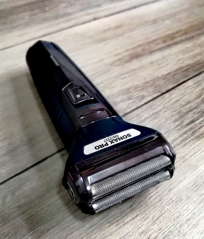 Elektryczna golarka SONAX PRO SN-7777 na drewnianej powierzchni, widok z góry pod kątem.