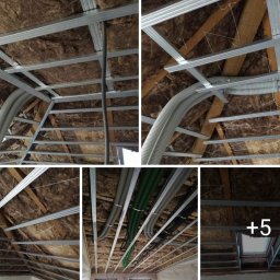 Ad-Serwis - Szkielet sufitu podwieszanego z widoczną izolacją z wełny mineralnej, rurami wentylacyjnymi i przewodami elektrycznymi przed montażem płyt gipsowo-kartonowych.