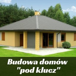 Ad-Serwis - Niski, parterowy dom z szarą dachówką, beżową elewacją i ceglanymi elementami dekoracyjnymi, otoczony trawnikiem i drzewami.