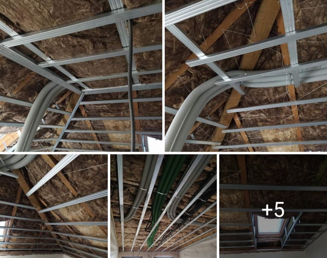 Szkielet sufitu podwieszanego z widoczną izolacją z wełny mineralnej, rurami wentylacyjnymi i przewodami elektrycznymi przed montażem płyt gipsowo-kartonowych.