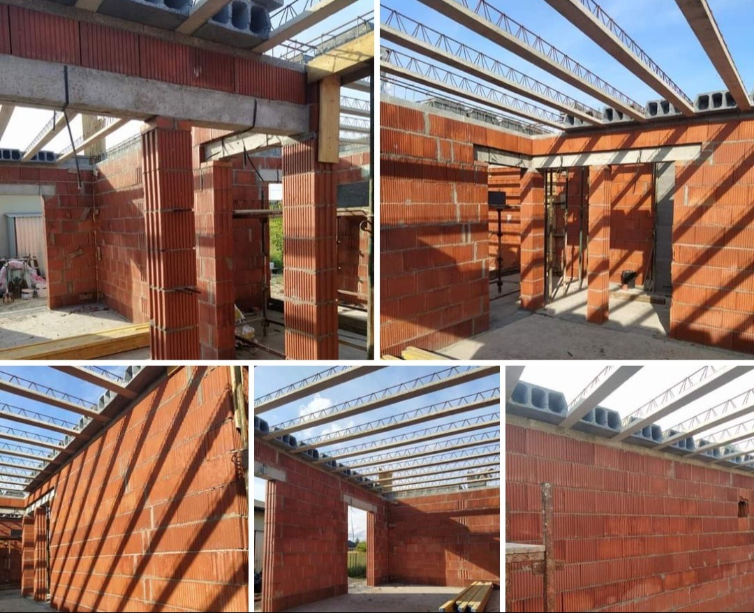 Wnętrze budynku w trakcie budowy z czerwonej cegły ceramicznej, widoczne zbrojenia i elementy konstrukcyjne stropu, w tle błękitne niebo.