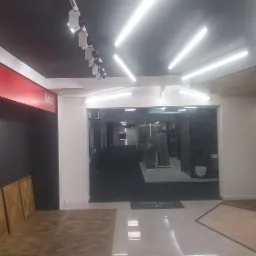 Wnętrze salonu z ekspozycją paneli podłogowych z drewna w różnych wzorach i kolorach, oświetlenie sufitowe LED, widoczne logo 'Imperio Collection by Lareco'.