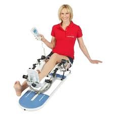 Kobieta uśmiecha się podczas rehabilitacji kolana na urządzeniu CPM z elektronicznym panelem sterowania.