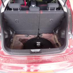 DB Service Dariusz Bryl - Czerwony samochód z otwartym bagażnikiem, w którym zamontowano okrągły zbiornik na gaz.