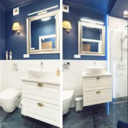 Niebiesko-biała łazienka z umywalką nablatową, toaletą wiszącą i kabiną prysznicową typu walk-in, ozdobiona obrazem Dziewczyny z Perłą w złotej ramie.