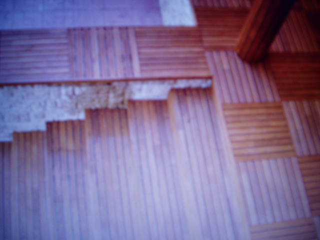 Drewniane schody i podłoga z desek ułożonych w kwadraty, widok z góry, rozmyte zdjęcie.