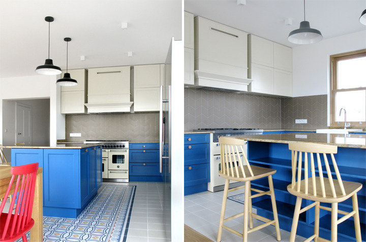 Nowoczesna kuchnia z wyspą w kolorze kobaltowym, kremowymi szafkami górnymi i wzorzystą podłogą, oświetlona wiszącymi lampami w stylu industrialnym.