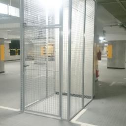 Przedsiębiorstwo Produkcyjno Handlowe MIRAMET Jerzy Kwiatkowski - Metalowa klatka z siatki zamykana na zamek, numer 28, w garażu podziemnym z betonowymi słupami i znakami poziomymi.