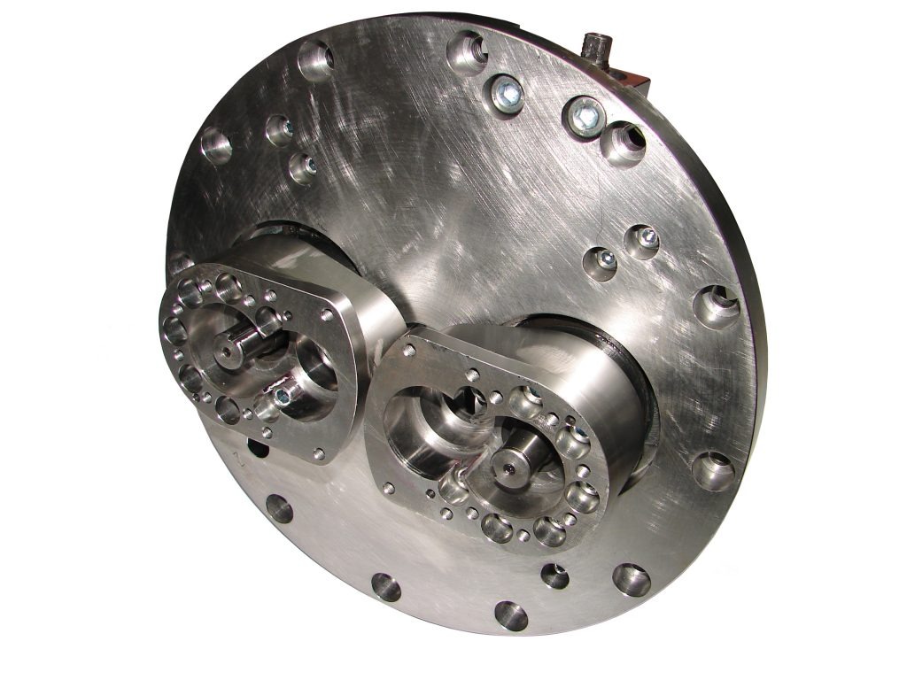 Obrabiany element z metalu o okrągłym kształcie z widocznymi otworami i frezowanymi detalami, obróbka wykończeniowa z widocznymi śladami po narzędziach.